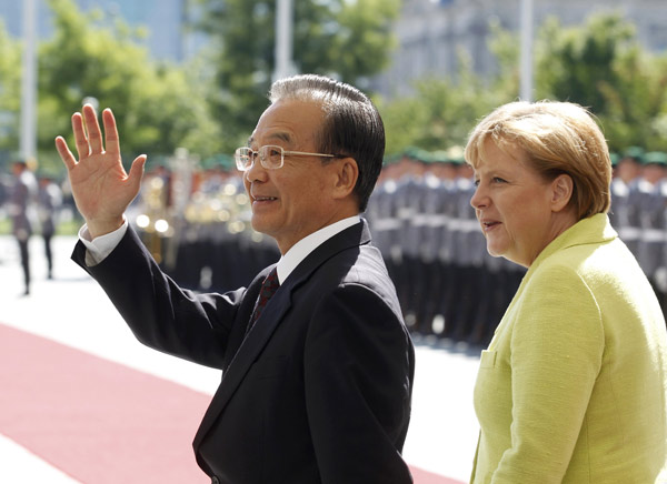 Premier Wen Jiabao, accompanied by German Chancellor Angela Merkel, inspects an honor guard on Tuesday during a welcome ceremony at the Chancellery in Berlin. [Photo/Agencies]