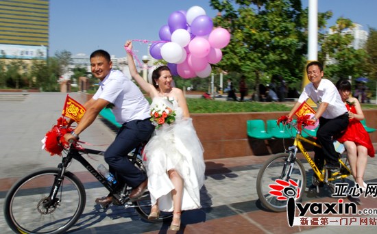 Li Wangang, the bridegroom, riding hard in front. His bride-to-be Yang Xinyi sat on his bike, wearing a white wedding dress.