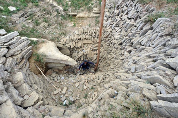 A farmer checks the bottom of a dried well in Leizhuang village in Guizhou province on Saturday. Severe drought has dried up 479 reservoirs and 349 rivers in the province, leaving more than 5.47 million people short of drinking water. [Photo/ China Daily]