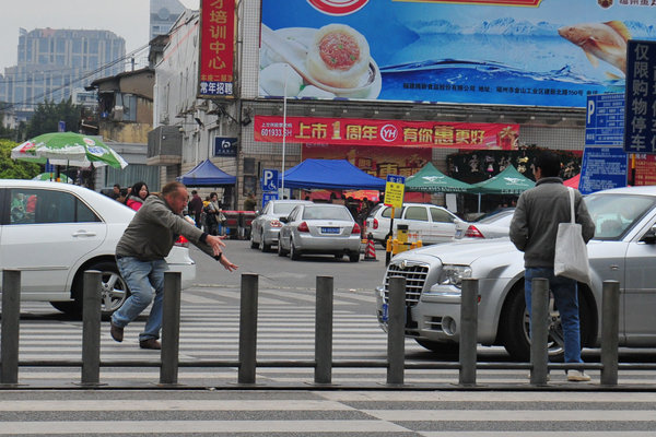 Uncle Ma forces cars to stop in front of zebra crossing in Fuzhou on Monday using tai chi.[Whats On Xiamen photo/CFP] 