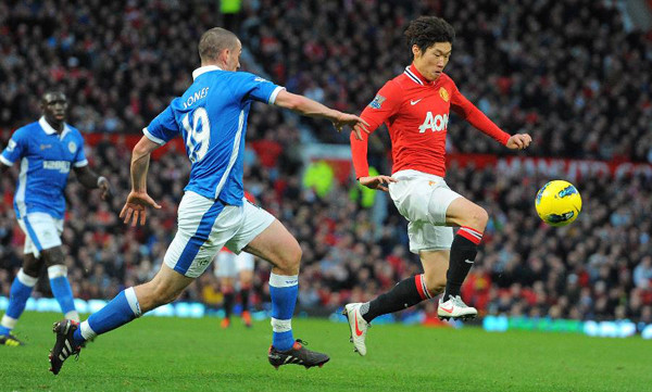 Players fight for the ball during the English Premier League football match between Manchester United and Wigan Athletic at Old Trafford in Manchester. United won 5-0. (Xinhua/AFP Photo)