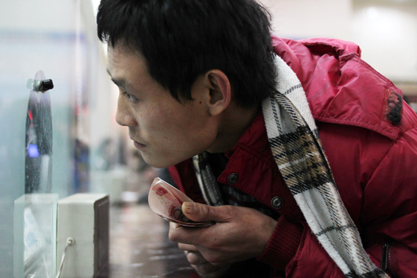 A man tries his luck buying a ticket at the Beijing Railway Station on Friday. Sales of tickets for the peak travel season of the Spring Festival started with long lines in stations. [Photo by Wang Ji