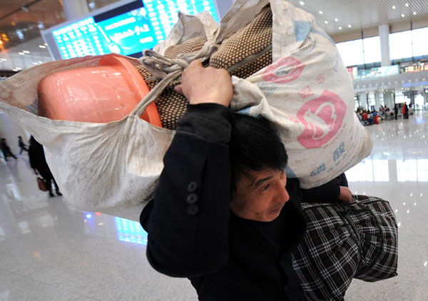 A migrant worker prepares to catch a train at the Nanjing South Railway Station in Nanjing, East China's Jiangsu province, Jan 8, 2012. China started its Spring Festival peak travel season on Sunday, with a total of 3.16 billion passenger trips expected during the 40 days. The Spring Festival, or Chinese Lunar New Year, falls on Jan 23 this year and is the most important traditional Chinese festival for family reunions. [Photo/Xinhua] 