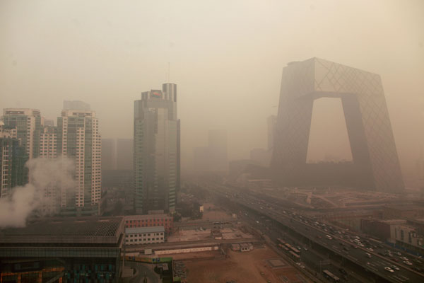 The headquarters building of China Central Television (CCTV) in Beijing is partially obscured by heavy fog on Wednesday. [Photo/China Daily]