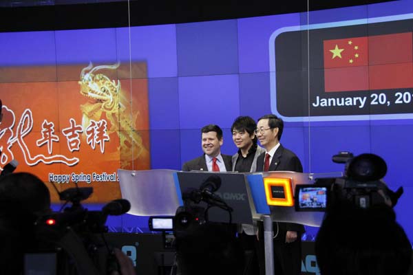 Chinese Consul General in New York Sun Guoxiang, pianist Lang Lang, and Nasdaq Senior Vice-President Robert McCooey pose a playing piano gesture on the Times Square in front of the Nasdaq MarketSite screen. 