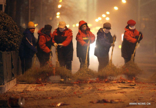 Sanitation workers clean the firecracker residue on a street in Beijing, capital of China, Jan. 23, 2012. A good deal of firecrackers has been set off on the eve of the Spring Festival as a kind of Ch