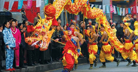 Residents in Southwest China's Chongqing municipality perform the dragon dance during a local arts festival on Dec 31, 2011. [Photo: Chen Cheng / Xinhua]