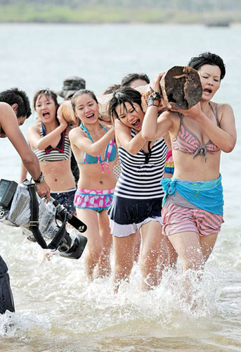 The young women carry a log on their shoulders during a training session for female bodyguards in Sanya, Hainan province, Jan 8, 2012. (China Daily)