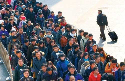 Hundreds of passengers wait to enter the subway as they leave Beijing Railway Station on Sunday. The transport network is facing peak demand as workers return from Spring Festival holidays. Photo by Zou Hong / China Daily 