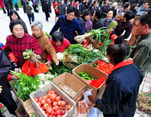 Sufficient supply: residents in Luoyang, Henan Province, buy vegetables at a community market.