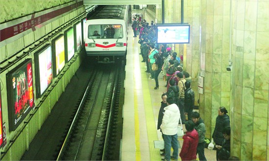 A first-generation subway train pulls to the platform at a station on Line 1 Monday. The last 19 such trains, 40 years old, will soon be out of service, making way for air-conditioned, more energy efficient ones. (Photo: Guo Yingguang/GT) 