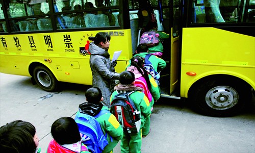 Primary school students in Chongming board one of their new school buses. [Photo: CFP]