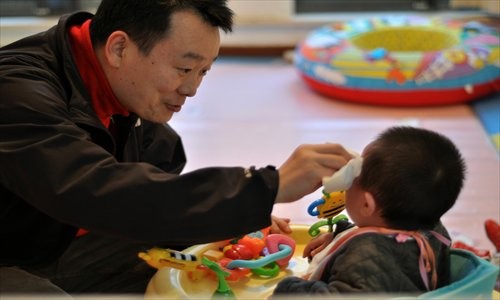 Li Yuqing looks after a baby with congenital foot disease at Lupin House. [Photo: Cai Xianmin/GT]