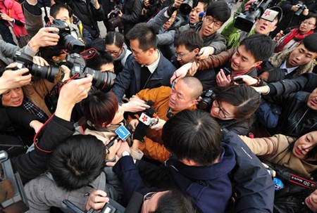 Shi Yongxin, abbot of Shaolin Temple, enters the Great Hall of the People for the opening ceremony of the Fifth Session of the 11th National Peoples Congress as journalists jostle for photos and interviews on Monday. KE XIAOJUN / CHINA NEWS SERVICE