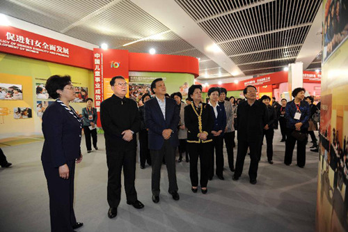 Li Changchun (2nd L, Front), a member of the Standing Committee of the Political Bureau of the Communist Party of China (CPC) Central Committee, attends an exhibition on the development of programs for women and children, in Beijing, capital of China, Mar