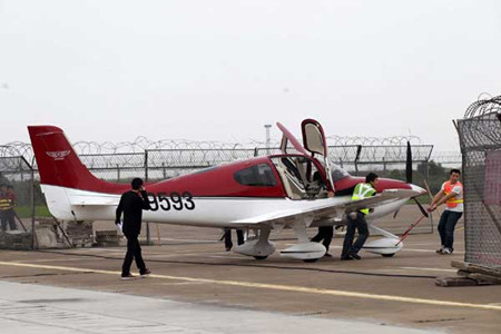 Staff workers of Zhuhai Xirui General Aviation Company transport a Cirrus aircraft in Zhuhai, Guangdong province, on Friday. Zhong Fan / for China Daily 