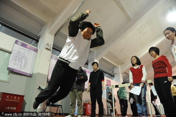 A student attempts a long jump during a physical fitness test at Tsinghua University, in Beijing, March 17, 2012. [Photo/CFP]