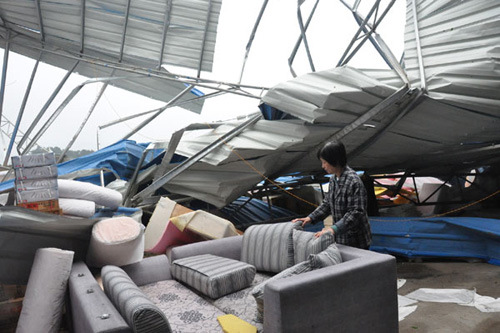 A woman checks the damage at a furniture warehouse after gale force wind struck in Lianzhou city of Qingyuan, South China's Guangdong province, April 5, 2012. Northern Guangdong province saw gusts of at least 70 km per hour and the city of Qingyuan experi