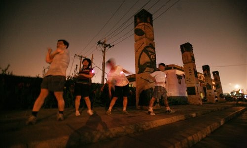 People, who prefer to run in the evening, warm up before getting into stride. [Photo: CFP]