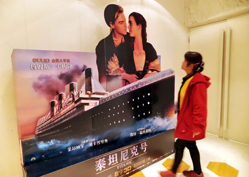 A woman in Shanghai is attracted by a poster for the 3D version of the movie Titanic. China's box-office revenues hit 13.15 billion yuan ($2.08 billion) last year. Jing Wei / For China Daily