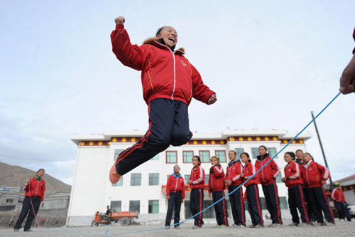 Children play on the grounds of a new orphanage school in Yushu, Qinghai Province, on Thursday. The Lanzhou Military Area Command of the People's Liberation Army aided the construction of the school. [Yang Yanmin / China News Service]