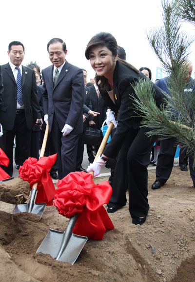 Thai Prime Minister Yingluck Shinawatra plants trees as she visits a Thai-owned enterprise in Beijing, April 19, 2012. [Photo/Asianewsphoto] 