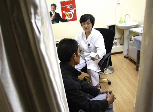 Dr Zhao Min, who heads the Wuhan AIDS Care Center, advises a patient on how to take his medicine. The center provides part-payment antiretroviral therapy for patients under a pilot program aimed at further optimizing the drug regimen and improving the delivery of services. Zhang Wei / China Daily