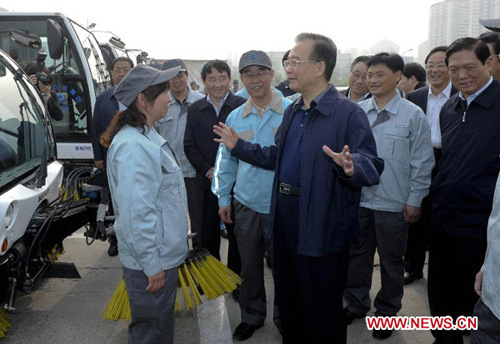 Chinese Premier Wen Jiabao, who is also a member of the Standing Committee of the Political Bureau of the Communist Party of China (CPC) Central Committee, talks with environmental sanitary workers in Beijing, capital of China, May 1, 2012, or Internation