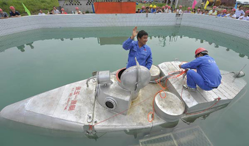 Zhang Wuyi, a 37-year-old former boilermaker, waves to onlookers before taking his self-made submarine under water in Wuhan, Hubei Province, on Tuesday. [Photo: China Daily]