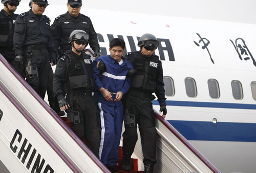 Naw Kham (2nd R, front), a drug lord suspected of masterminding the murder of 13 Chinese sailors on the Mekong River last year, is escorted to get off the plane in Beijing, capital of China, May 10, 2012.[Photo/Xinhua]