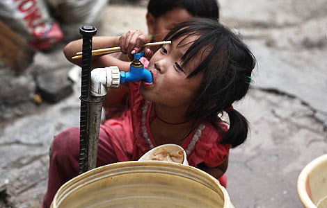 Wang Yaya drinks from a water tap in Guiyang, Guizhou Province. [Photo: Wang Jing/China Daily]