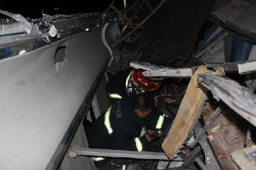 Rescuers work at the accident site after a coach collided with a truck in Ulanqab City, north China's Inner Mongolia Autonomous Region, May 14, 2012. At least four people were confirmed dead and more than 30 others were injured in the accident which happened early Monday morning. (Photo: Xinhua/Wang Chao)