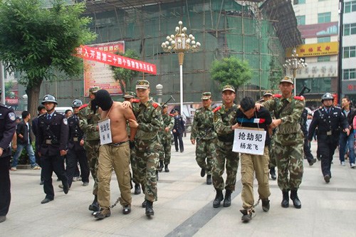 Two criminal suspects are escorted on a perp walk in Luonan county, Northwest China's Shaanxi Province, May 13, 2012. [Photo/163.com]