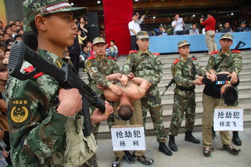 Two criminal suspects are escorted on a perp walk at a square in Luonan county, Northwest China's Shaanxi Province, May 13, 2012. [Photo/163.com]