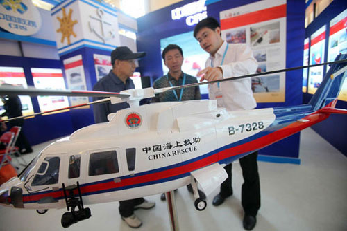 A staff member introduces a rescue helicopter model to visitors during the 11th China International Exhibition on Transport Technology & Equipment (CHINA TRANSPO 2012), Beijing, May 15, 2012. [Photo/Xinhua]