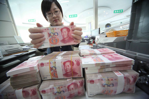 An employee bundles yuan notes at a bank in Ganyu county, Jiangsu province. China's top securities regulator says the currency will become fully convertible not long from now. Si Wei / for China Daily 