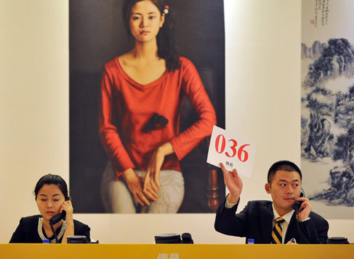 A woman takes a phone bid at Beijing Tranthy's 2012 Spring Auction on May 16. Hu Yilin / China Daily