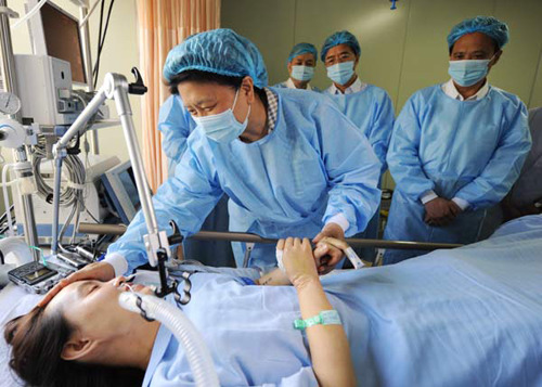 State Councilor Liu Yandong (center) pays a visit to Zhang Lili, a teacher seriously injured by a bus after pushing students out of danger, at the intensive care unit of the First Affiliated University of Harbin Medical University on Sunday. Guo Junfeng / for China Daily