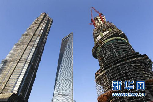 The Shanghai Tower (R), which is currently under construction, reaches 303.5 meters in height on Tuesday.[Xinhua]