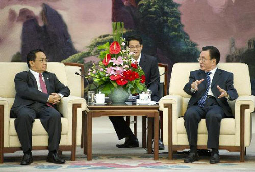 He Guoqiang (R), a member of the Standing Committee of the Political Bureau of the Communist Party of China (CPC) Central Committee and also secretary of the CPC Central Commission for Discipline Inspection, meets with Laos Prime Minister Thongsing Thamma