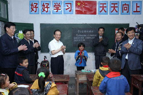 Chinese Premier Wen Jiabao (C, left) claps hands when the children sing a song in the Maoping Primary School in Maoping Village, Morong Town of Guzhang County, central China's Hunan Province, May 25, 2012. During an inspection tour on poverty-reduction in the Wuling mountainous area in Hunan Province, Wen Jiabao visited children of the primary schools in the rural area to bid them greetings ahead of the International Children's Day, which falls on June 1. (Xinhua/Pang Xinglei)