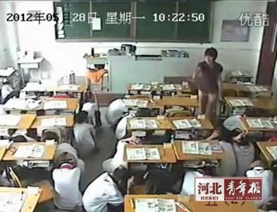 A still image from video footage shows students duck under the desk as the magnitude 4.8 earthquake hits Tangshan on May 28, 2012. [Photo/Hebei Youth Daily]