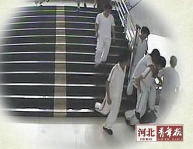 A still image from video footage shows students help a classmate with injured leg evacuate as the magnitude 4.8 earthquake hits Tangshan on May 28, 2012. [Photo/Hebei Youth Daily]