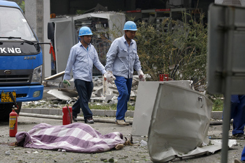 A dead woman is covered with a blanket following a power plant explosion at Taiyanggong in Beijing on Wednesday. Zhu Xingxin / China Daily 