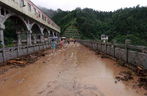 Residents walk on a mud road in Anren County, central China's Hunan Province, June 11, 2012. Torrential rains swept across Hunan over the past few days, killing nine people and affecting 1.1 million, local authorities said on Tuesday. (Xinhua) 