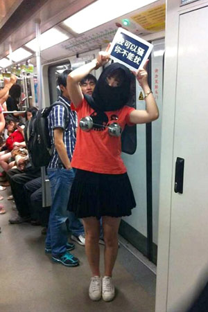 A woman holds a sign reading I can be coquettish, but you can't harass me on Shanghai Metro Line 2 on Sunday. Provided to China Daily