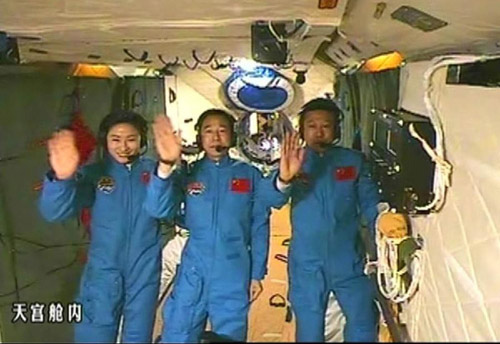 This screen shot taken on June 26, 2012 shows the Chinese astronauts who are conducting scientific tests in Tiangong-1 space lab module waving hands in Tiangong-1. Chinese President Hu Jintao came to the Beijing Aerospace Control Center on Tuesday and talked with the astronauts. (Xinhua)