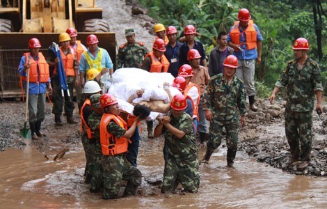 Rescuers rush an injured person to safety on Th ursday aft er torrential rain triggered mudslides in Ningnan county, Sichuan province. A massive search and rescue operation was launched aft er 40 people were feared missing. [Photo/Xinhua]  