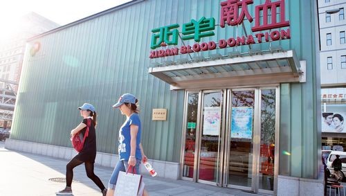 Pedestrians walk past Xidan Blood Donation Center Monday. Starting from Sunday, lesbians are allowed to donate blood in China.