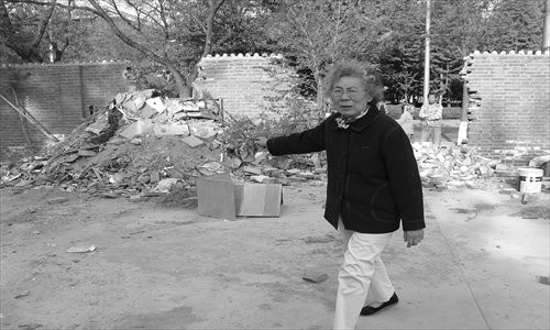 Ma Xiuming gestures to her demolished courtyard, the site of which is slated to be developed into a residential complex.